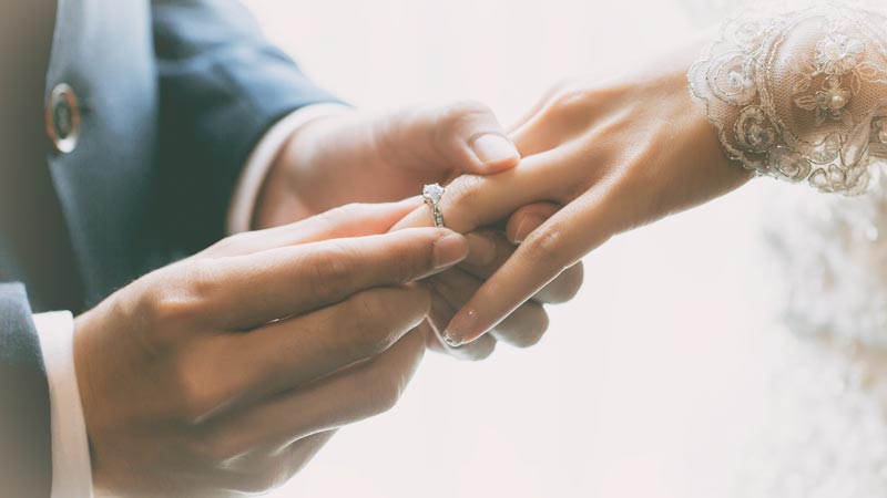 Couple exchanging wedding rings.