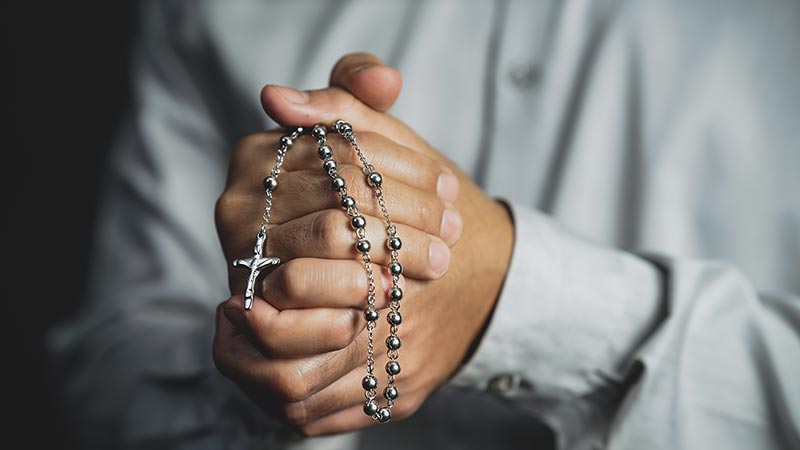 Praying in church with a rosary.